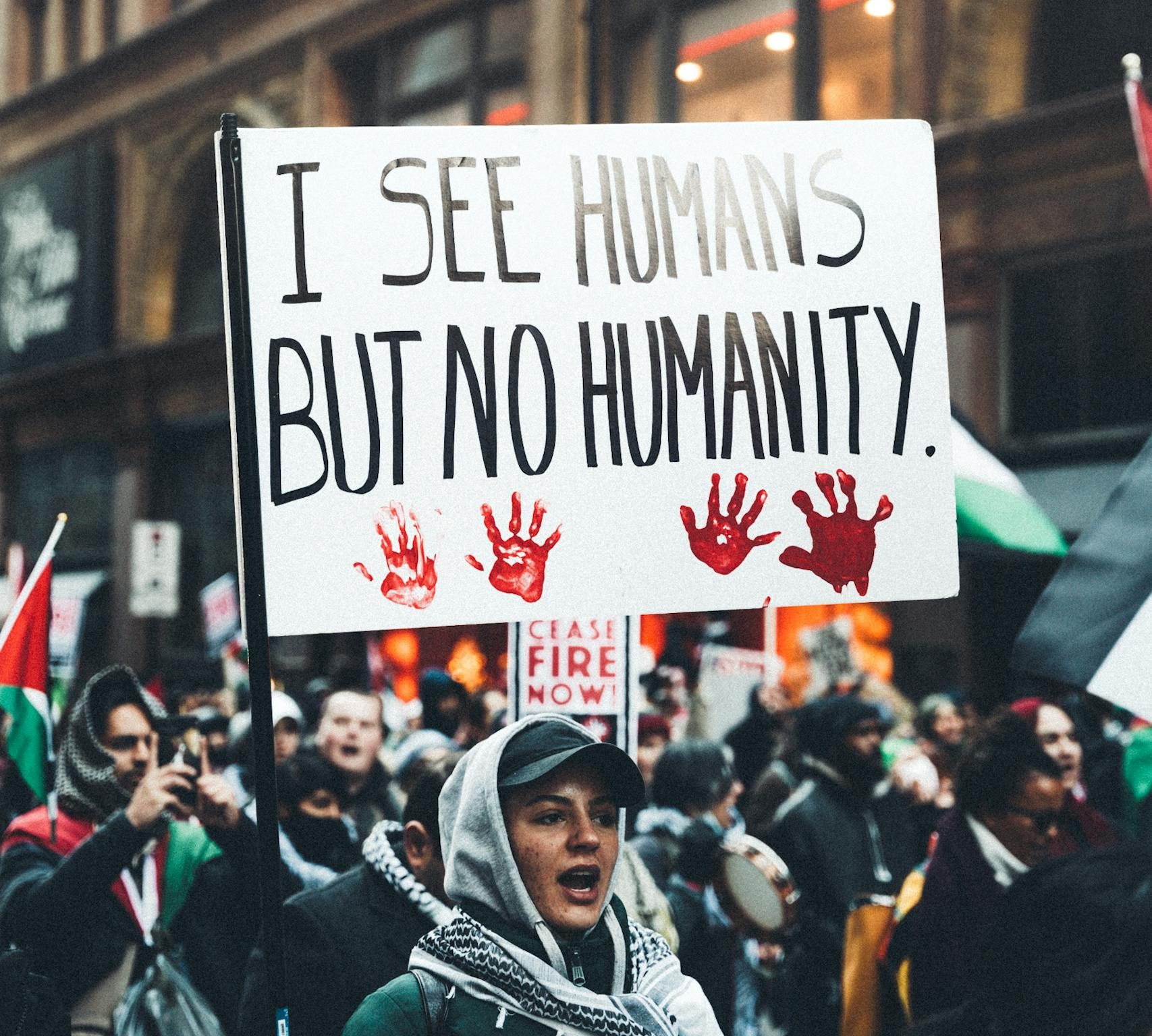 Protesters holding signs advocating for human rights and social justice in an urban setting.