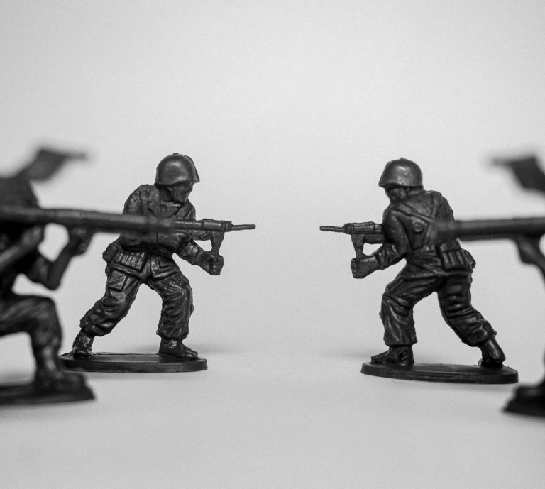 Black and white photo of toy soldiers in a battle stance with rifles ready.